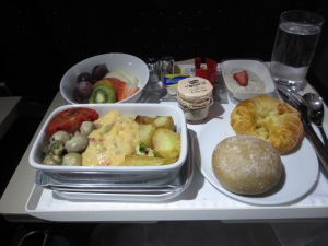 airline breakfast tray with fresh fruit, hot dish, burcher muesli, croissant and breadroll