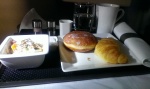 Etihad business class breakfast on tray with yoghurt, croissant and donut, mug of coffee