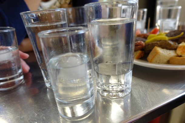 glasses of tsipouro and water at a cafe in Athens fish market