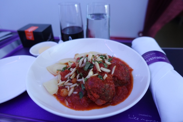 plate of lamb meatballs with tomato sauce on a white plate, served on a tray on Virgin Australia business class