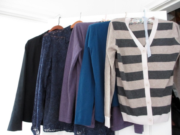 row of jackets, cardigans and blouses on hangers