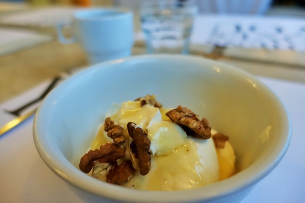 Bowl of Greek yoghurt with honey and walnuts scattered on top